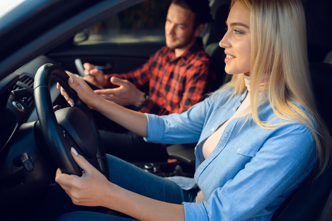 Élève et moniteur souriants pendant une leçon de conduite Pink Permis